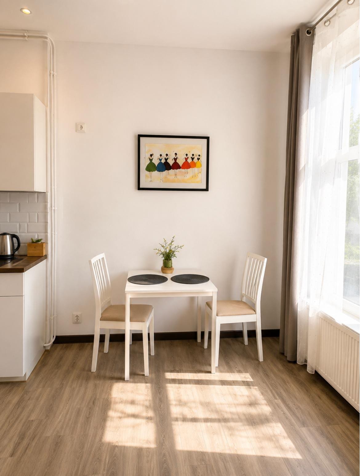 Apartament nr 2 — część jadalniana z białym stołem i aneksem kuchennym, Willa Pod Platanem Bytów