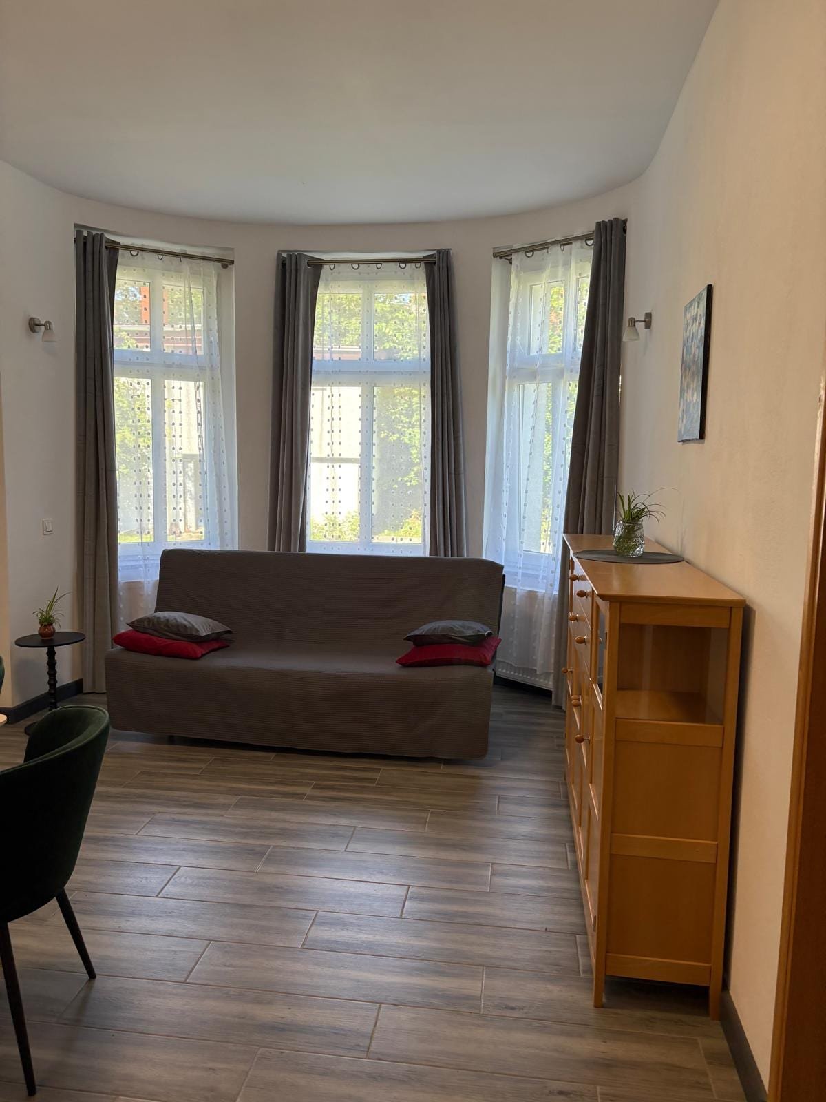 Apartament nr 4 — salon z rozkładaną sofą przy oknach, Willa Pod Platanem Bytów