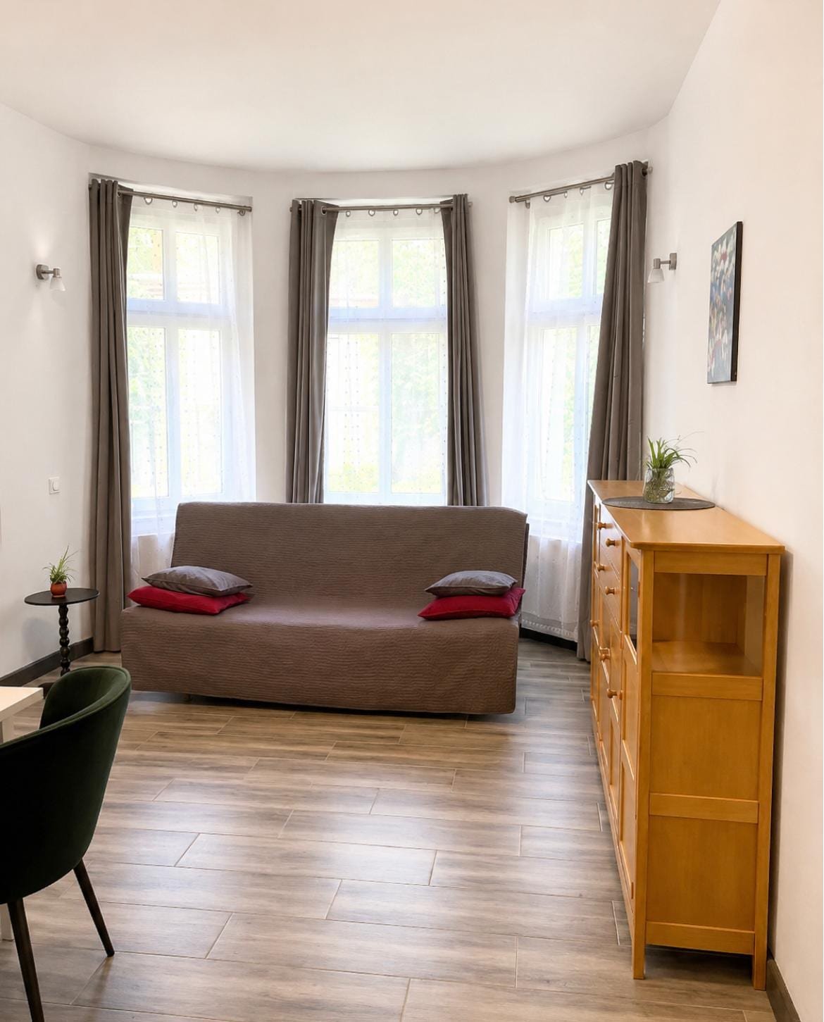 Willa Pod Platanem Bytów — Apartament nr 4 — salon z rozkładaną sofą w wykuszu