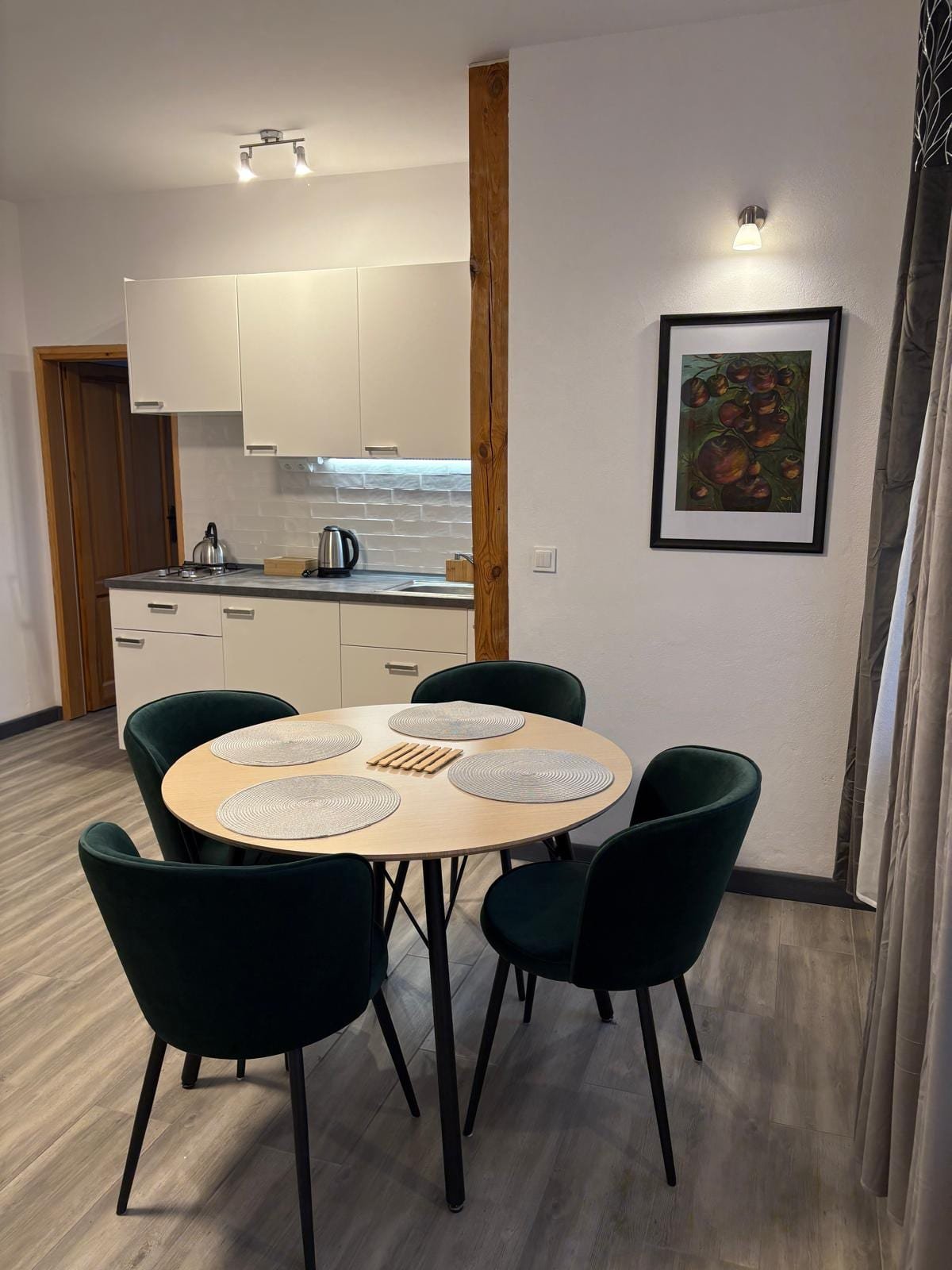 Apartament nr 5 — część jadalniana z zielonymi krzesłami, Willa Pod Platanem Bytów